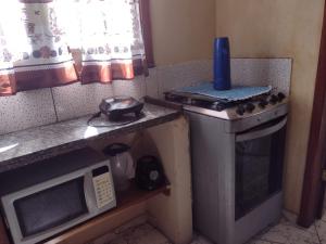 伊列乌斯Sobrado aconchegante的一间带炉灶和微波炉的小厨房