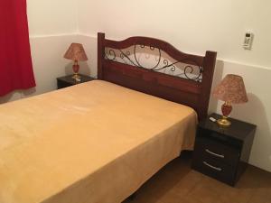 皮里亚波利斯Cami III的一间卧室配有一张床和两个带灯的床头柜