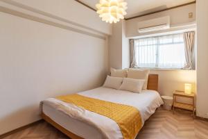 大阪环球湾公寓式酒店的一间卧室设有一张床和一个窗口