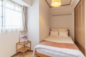 大阪环球湾公寓式酒店的一间小卧室,配有床和窗户