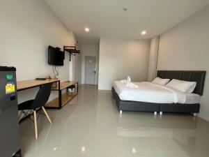 Ban MaiLife Hotel Rong Khun的酒店客房配有一张床、一张书桌和一张书桌。