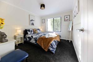戴尔斯福特Hidden Gem ~ Luxury Cottage near Lake Daylesford的一间卧室设有一张床和一个窗口
