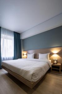阿拉木图Resident Hotel Kazybek Bi的卧室配有白色大床和蓝色的墙壁