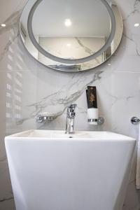 阿拉木图Resident Hotel Kazybek Bi的浴室设有白色水槽和镜子