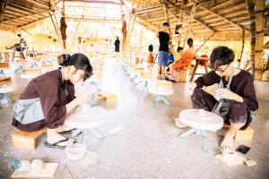 Dak LakLang's Pá Mé - Homestay - Bungalow - Camping Krông Pắk, Buôn Mê Thuột, Đắk Lắk, Việt Nam的一群在房间家具上工作的人
