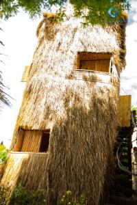 Dak LakLang's Pá Mé - Homestay - Bungalow - Camping Krông Pắk, Buôn Mê Thuột, Đắk Lắk, Việt Nam的茅草屋顶的建筑