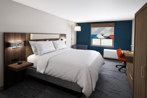 普莱诺HOLIDAY INN EXPRESS & SUITES DALLAS PLANO NORTH, an IHG Hotel的卧室配有一张白色大床和一张书桌