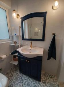 马萨尔福恩Lucky Summer Marsalforn Holiday Apartment的一间带水槽和镜子的浴室