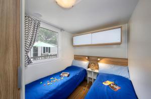 卡里高多Albatross Mobile Homes on Camping Park Umag的小型客房 - 带2张床和窗户