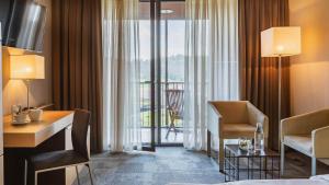 博德森特克索特利尔欧里米尔温泉酒店的配有一张床、一张书桌和一扇窗户的酒店客房