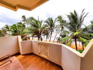 卡卢特勒Hotel Coconut Bay的享有海滩和棕榈树景致的阳台
