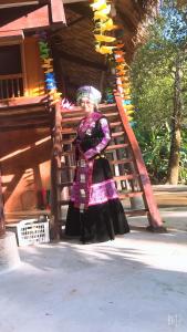 Xuan DamBee lucky homestay cat ba Island的身着服装的女人站在建筑物前