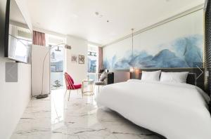 釜山De Homme Hotel的卧室配有一张白色大床和一张书桌