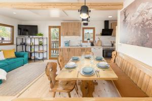 博希尼Captain's Lodge的厨房以及带木桌和椅子的客厅。