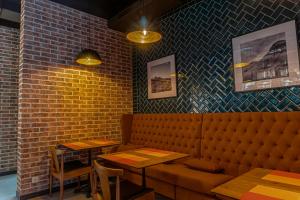 阿拉木图Resident Hotel Kazybek Bi的餐厅设有长凳、桌子和砖墙