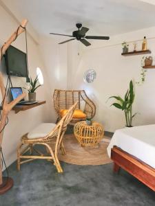 卢纳将军城Happiness Beach Resort Siargao的一间卧室配有椅子、一张桌子和一张床