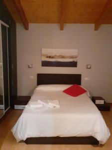 罗德里戈城Ciudad Rodrigo La Casa Azul的卧室配有一张带红色毯子的白色床