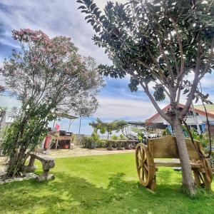 SibulanSEAVIEW BEACH RESORT的木凳坐在树旁的草上