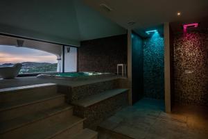 斯库索港Hotel Lido degli Spagnoli Wellness & Spa的带浴缸和楼梯的景观浴室