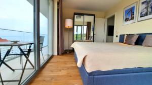 米兹多洛杰Ferienwohnung A102 mit Komfort in Strandnähe mit Terrasse und Meerblick in 10ter Etage PARKING FREE的一间卧室配有一张床,阳台配有桌子