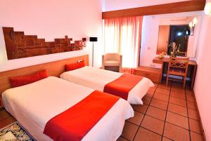 科武港Hotel Apartamento Porto Covo的酒店客房配有两张床和一张书桌