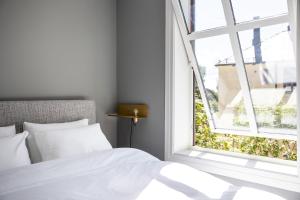 奥斯陆Frogner House - Uranienborg的卧室配有白色的床和开放式窗户。