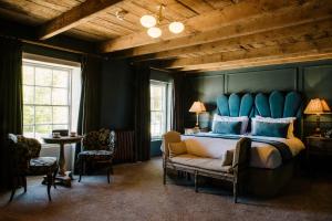 奥特本Le Petit Chateau & William de Percy的一间卧室配有一张大床和蓝色床头板