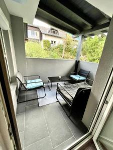 菲拉赫AB Apartment Moderne Zweizimmerwohnung的阳台配有桌椅。