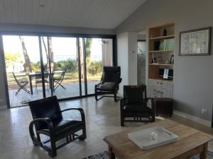 里夫杜海滩Villa Ile de Re avec acces mer du jardin的客厅配有椅子和桌子