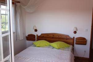 库伊布劳科英布拉露营地/公寓的一间卧室配有一张带两个绿色枕头的床