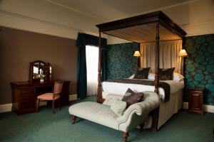 因弗内斯力推尼斯湖乡村宅邸酒店的一间卧室配有一张天蓬床和一把椅子