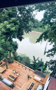 琅勃拉邦占城河景月光酒店的配有桌椅的甲板上享有湖景