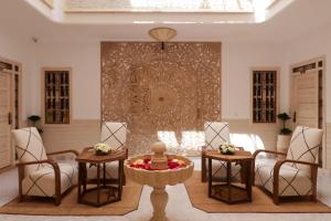 马拉喀什Riad Wazani Square & SPA的客厅配有两把椅子和一张桌子