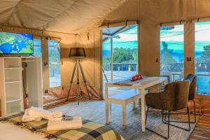 克兰尼蒂African Safari Canvas Lodge Tent Sea View的帐篷内的房间,配有桌子和电视