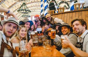 慕尼黑AllYouNeed Oktoberfest camping的一群人坐在一桶啤酒的桌子上