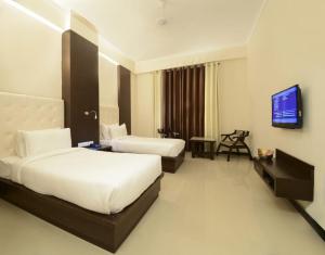 阿格拉Hotel Crimson Palace的酒店客房设有两张床和一台平面电视。