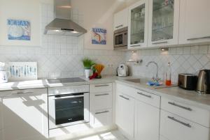 巴贝Haus Meeresblick FeWo Strandperle的白色的厨房设有水槽和炉灶。