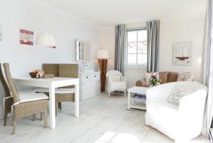 巴贝Haus Meeresblick FeWo Strandperle的白色的客厅配有白色的桌子和椅子