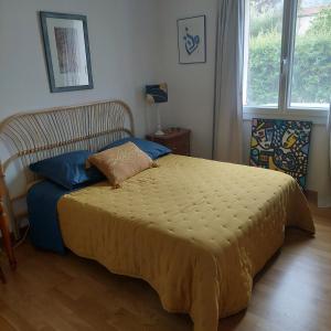 锡斯特龙Etxe Laminak的一间卧室配有一张带蓝色枕头的床和一扇窗户。