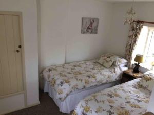 斯多克兰Fern Dale Cottage的一间卧室设有两张床和窗户。