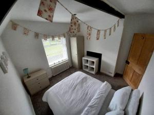 霍顿利斯普林Unique Countryside Cottage close to Sunderland的一间卧室配有一张床和一面带旗帜的窗户