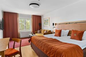 兰德维特Landvetter Airport Hotel, Best Western Premier Collection的酒店客房设有一张带橙色毯子的大床