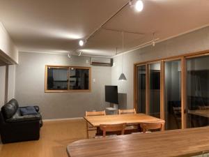 白马村Yuhike House Misorano的客厅配有木桌和沙发