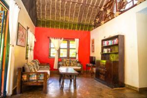 迪亚尼海滩Oasis Diani Beach Villas的客厅设有红色的墙壁、一张沙发和一张桌子