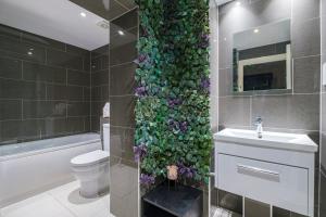 伦敦Larger Groups Apartment with Garden and Parking的浴室设有鲜花绿墙