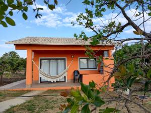 皮雷诺波利斯Pousada Refúgio da Serra的一座橙色的小房子,前面设有吊床