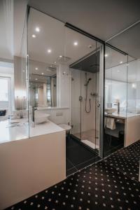 乌尔姆Boutique Hotel am Rathaus - Reblaus的一间带玻璃淋浴和水槽的浴室