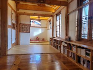 首尔Chaehyodang Hanok Stay的建筑里一间空房间,里面装有书架和窗户