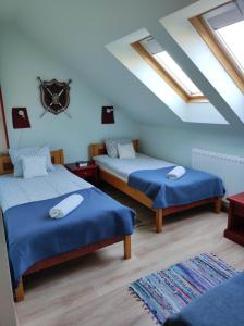HerendHolló és Bárány Vendégház的一间卧室设有两张带蓝色床单和窗户的床。