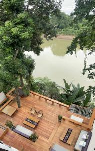 琅勃拉邦占城河景月光酒店的湖景甲板配有椅子